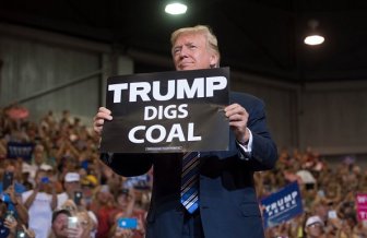 US President Donald Trump holds up a "Trump Digs Coal" sign as he arrives to speak during a Make America Great Again Rally at Big Sandy Superstore Arena in Huntington, West Virginia, August 3, 2017. / AFP PHOTO / SAUL LOEB (Photo credit should read SAUL LOEB/AFP/Getty Images)